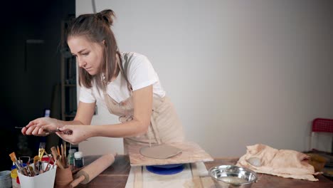 woman working on pottery on a pottery wheel