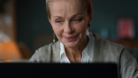 Portrait-of-sentimental-old-woman-looking-computer-screen-in-luxury-interior.