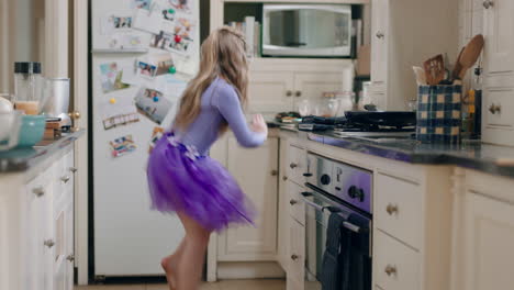 happy ballerina girl dancing in kitchen wearing purple tutu having fun performing funny dance moves enjoying weekend celebration at home