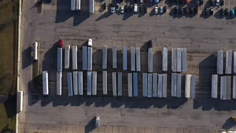 Toma-Aérea-De-Arriba-Hacia-Abajo-Sobre-Un-Estacionamiento-Lleno-De-Semirremolques-Y-Camiones-Cerca-De-Chicago