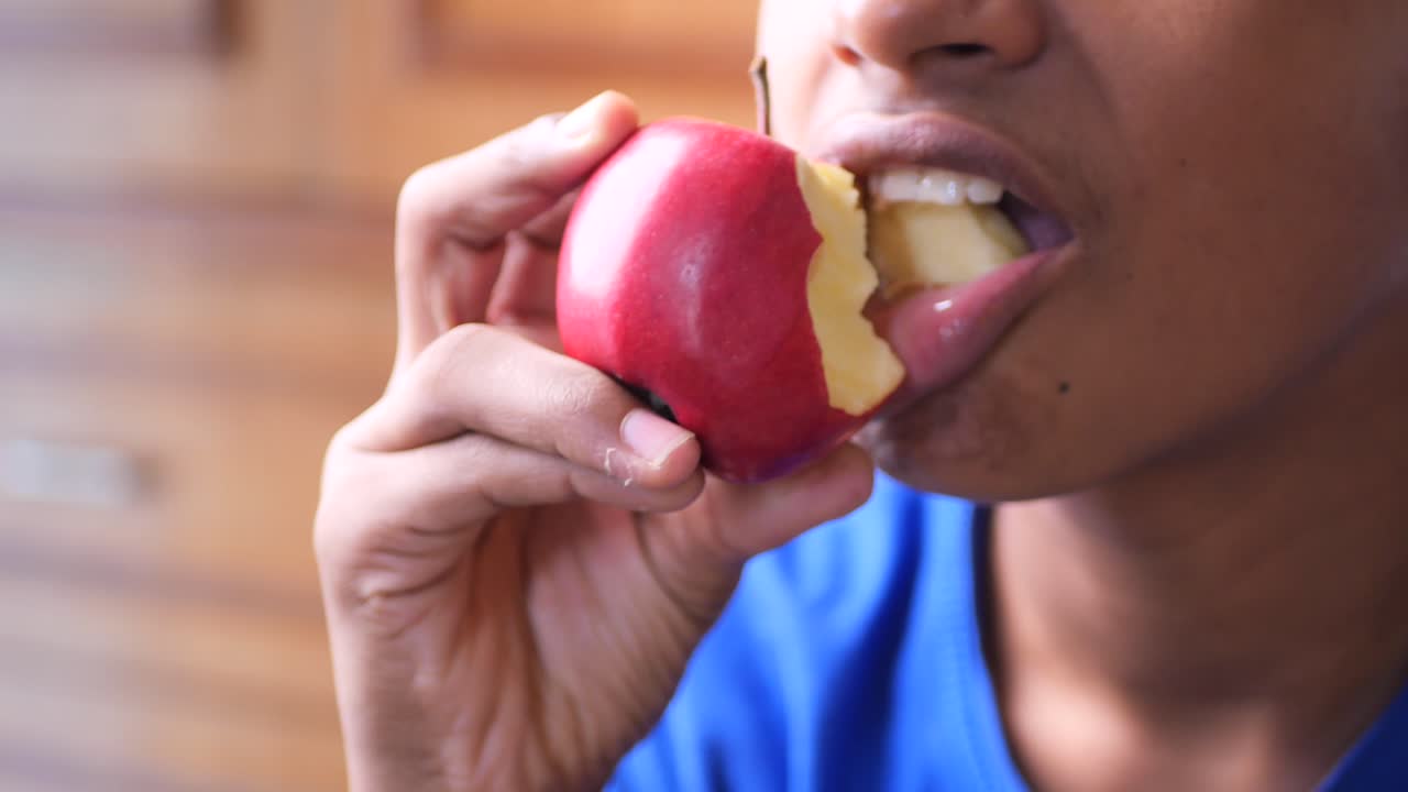 Boy eating a red apple