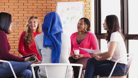 mujeres internacionales diversas sentadas y participando en reuniones de grupo