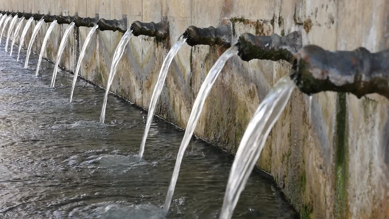 Side view of the iron pipes in a row of the Fountain of the 25 Pipes of Loja