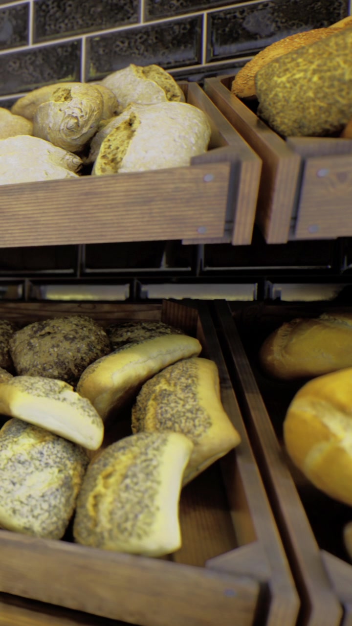 Fresh bread displayed in wooden racks at a local bakery during the day