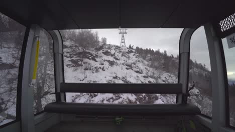 Voss-Gondola-descending-hillside-snowy-mountain-view-from-inside---Norway