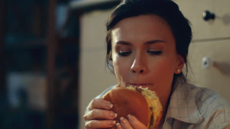 hungry girl eating burger on floor