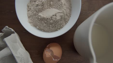 messy kitchen table with raw baking ingredients and tools