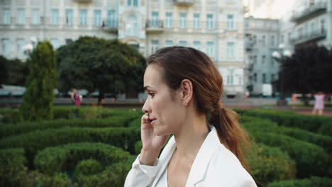 Portrait-of-annoyed-female-professional-arguing-on-mobile-phone-in-city-walk.