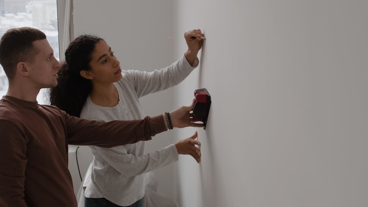 Couple Using Laser Level for Home Improvement Project