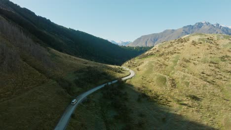 Vista-Aérea-Por-Drones-De-Una-Autocaravana-Turística-En-Una-Remota-Y-Sinuosa-Carretera-Hacia-El-Lago-Moke-En-Otago,-Isla-Sur-De-Nueva-Zelanda-Aotearoa