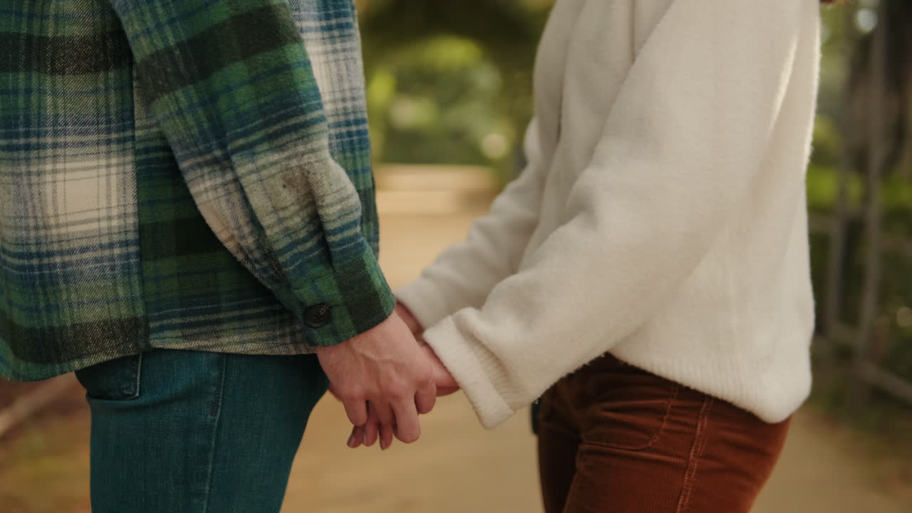 Young couple holding hands, close-up of hands