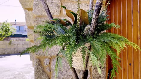 cedar leaf fern branches ornate plant arrangement in tripod of sticks