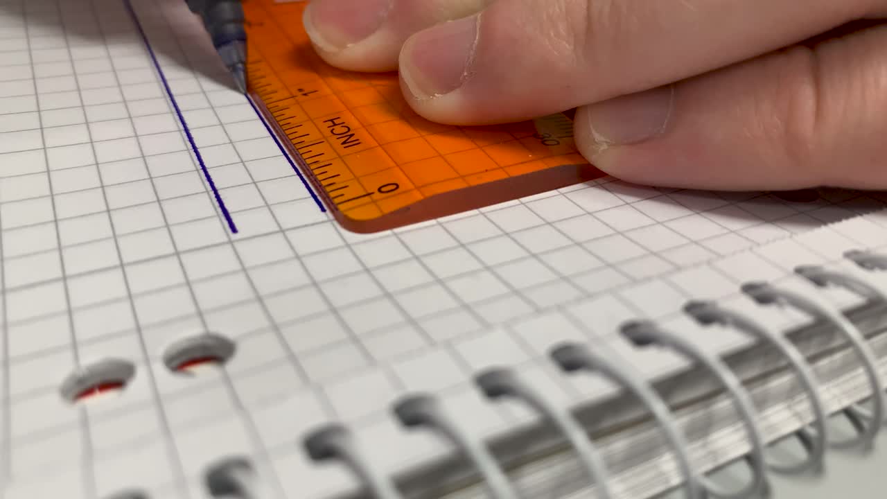 dibujar líneas con una regla en una hoja de papel en un bloc de notas