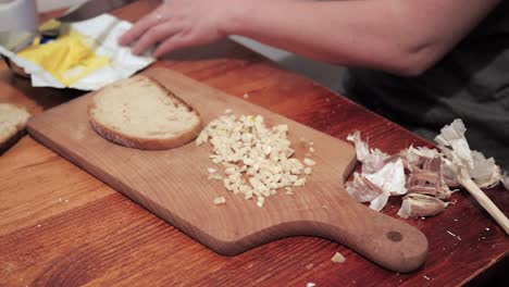 La-Mano-De-La-Mujer-Toma-Una-Rebanada-De-Pan,-La-Unta-Con-Mantequilla