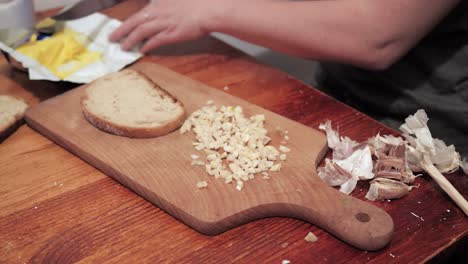woman's hand takes a slice of bread, smears it with butter