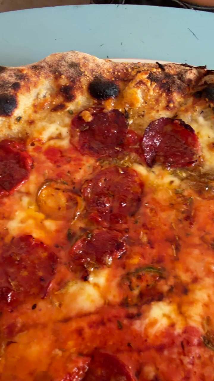 Primo piano di una pizza ai peperoni appena sfornata su un piatto