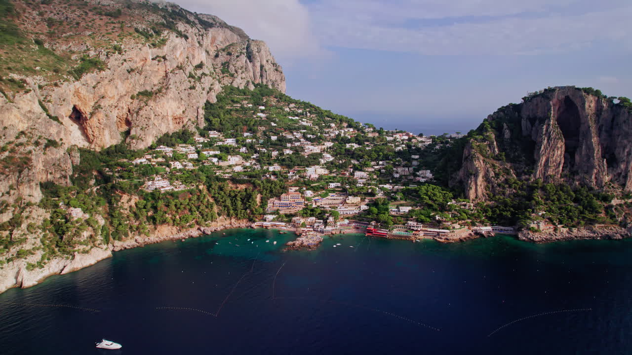 아말피 해안을 따라 이탈리아에서 인기 있는 고급 휴양지인 유명한 섬 카프리의 마리나 피콜라 주변의 멋진 풍경을 드러내기 위해 뒤로 물러나는 넓은 항공 사진