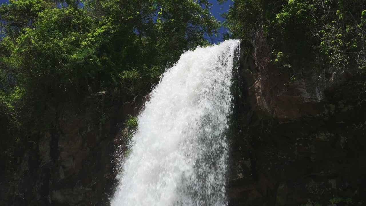 vista desde lo alto de un río ancho que cae desde un enorme acantilado, una gran cascada alta que cae desde un borde empinado en una selva rocosa ubicación escénica en las cataratas de iguazú, argentina, américa del sur
