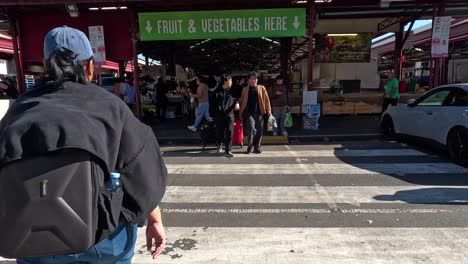 peatones cruzando la carretera hacia el mercado de la reina victoria