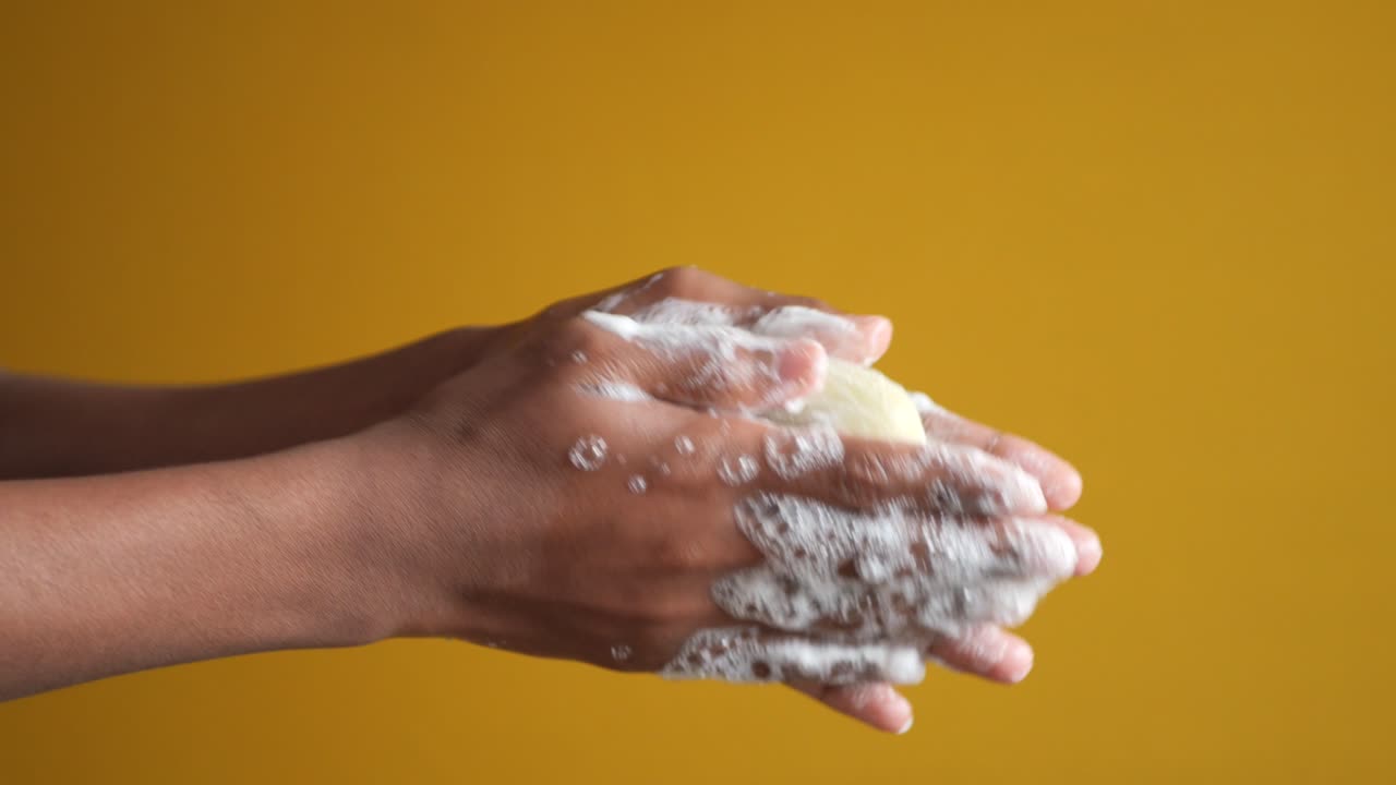 Young man washing hands with soap warm water