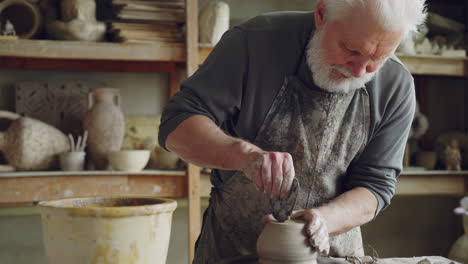 senior potter shaping clay