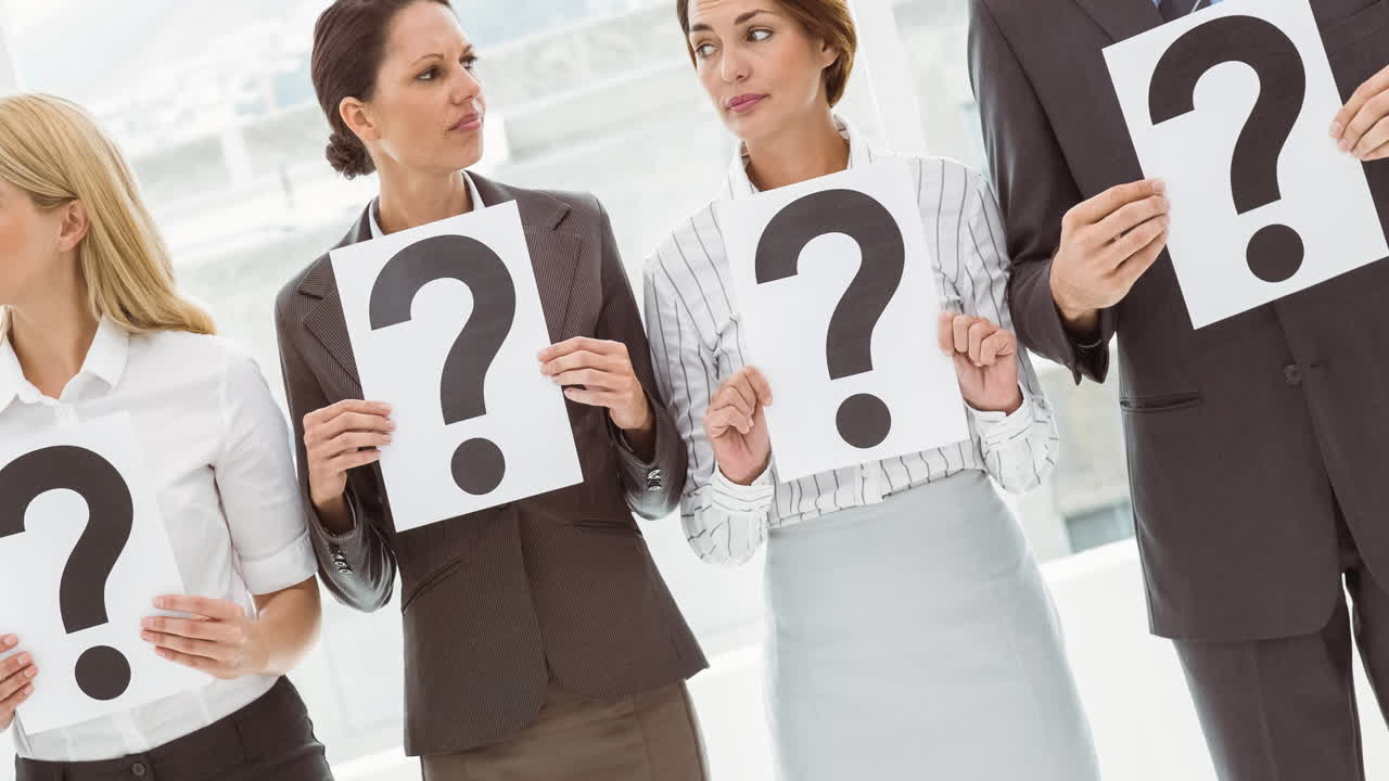 혼란스러운 백인 사업가와 사업가 여성 그룹이 질문표 표지판을 들고 있습니다.