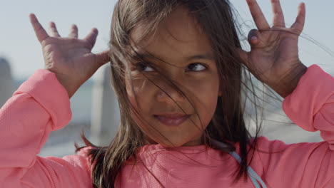 de cerca una niña juguetona haciendo caras disfrutando de un divertido día soleado en las vacaciones de verano