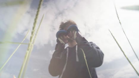 Young-adult-male-jabbing-with-boxing-gloves-standing-up-in-long-grass