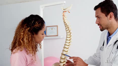 Physiotherapist-explaining-the-spine-model-to-patient
