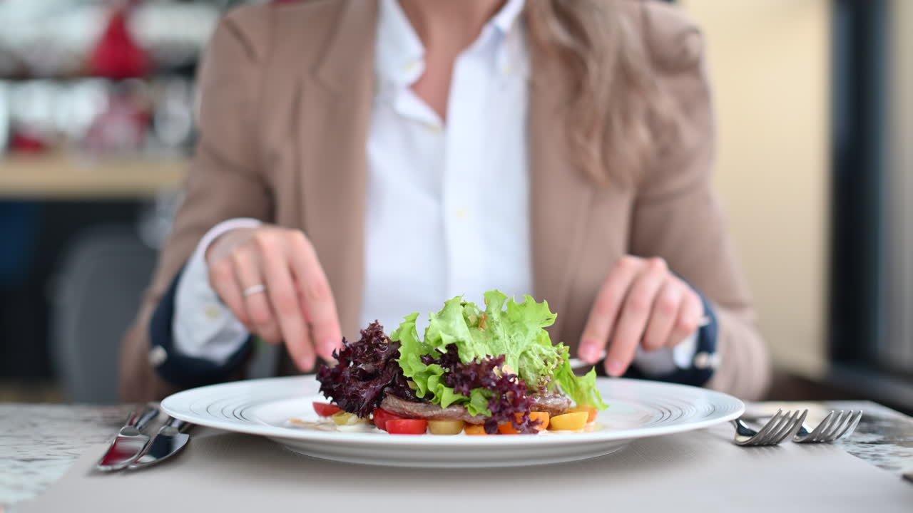 Woman eating a beef meat salad with vegetables at a restaurant