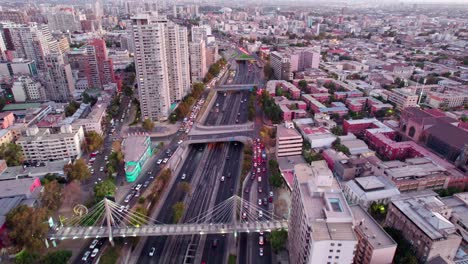 Aerial-view-following-downtown-Santiago-Hufanos-bridge-central-highway-during-rush-hour,-Chile