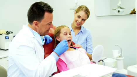 Dentist-examining-a-young-patient-with-tools