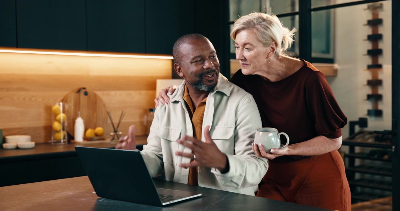 Mature Couple Using Laptop Together in Modern Kitchen
