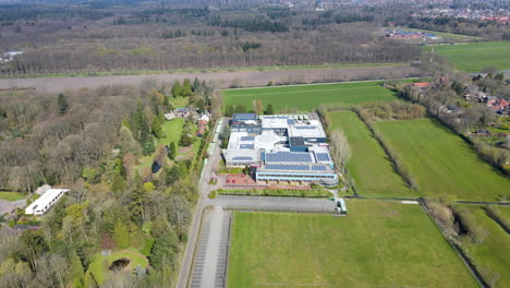 aerial of large rural high school with solar panels on rooftop