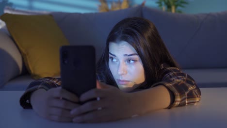 unhappy and depressed young woman using smartphone.