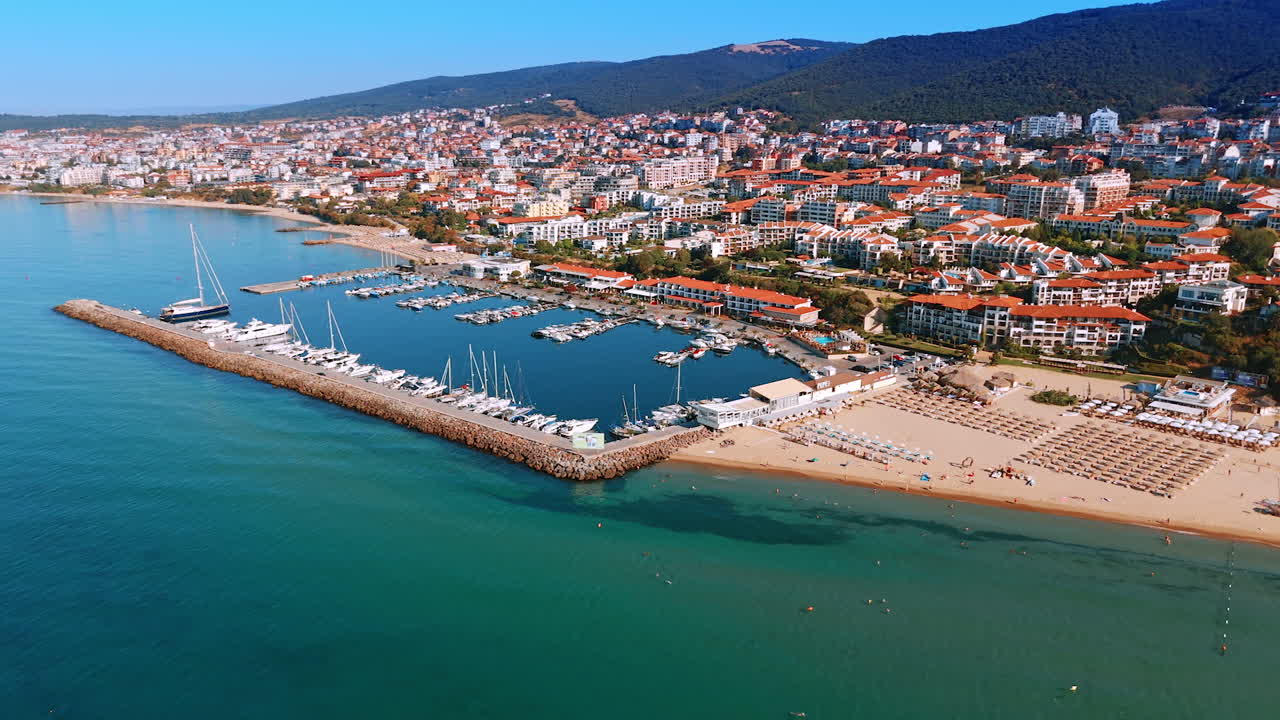 Black Sea shore on sunny day. Drone footage along the yacht club, sandy beach and dense hotel infrastructure in Sveti Vlas, Bulgaria