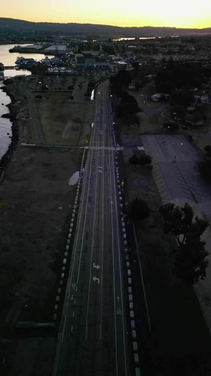Aerial drone footage looking directly down at a car driving on a road in west Alameda California.