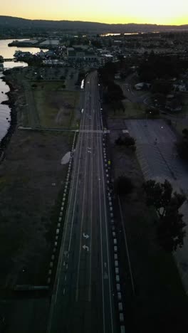 aerial drone footage looking directly down at a car driving on a road in west alameda california.
