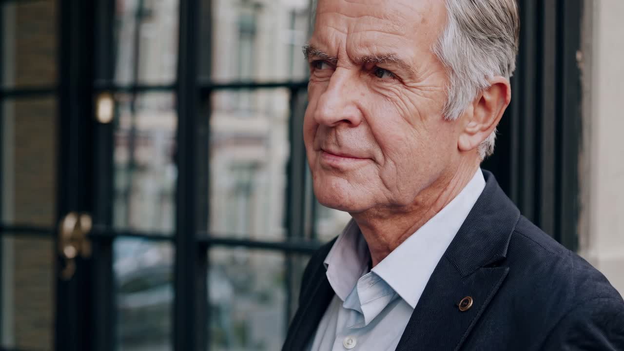 Professional senior businessman looking at camera and slightly smiling, posing for a series of corporate portraits with different expressions and poses