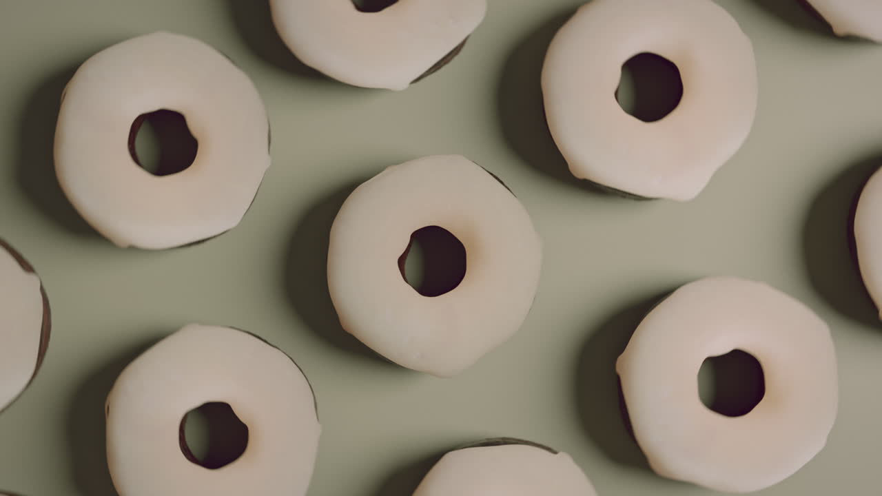 White glaze donuts on a light green background