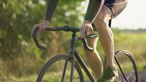 cropped view a male cyclist rides bicycle along the road