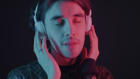 man listening to music with headphones in neon light
