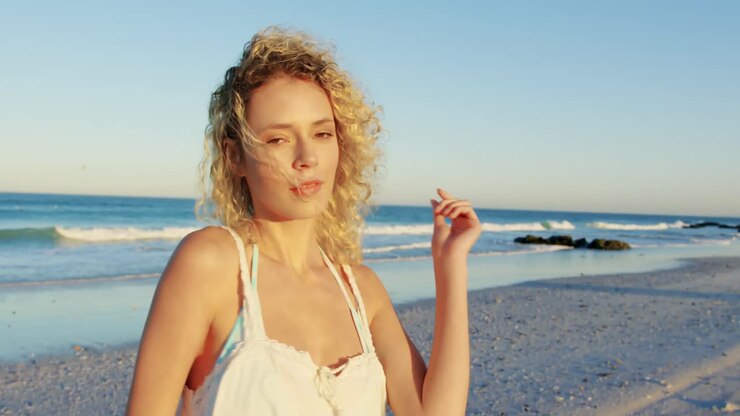 Giovane donna che passeggia su una spiaggia 4k