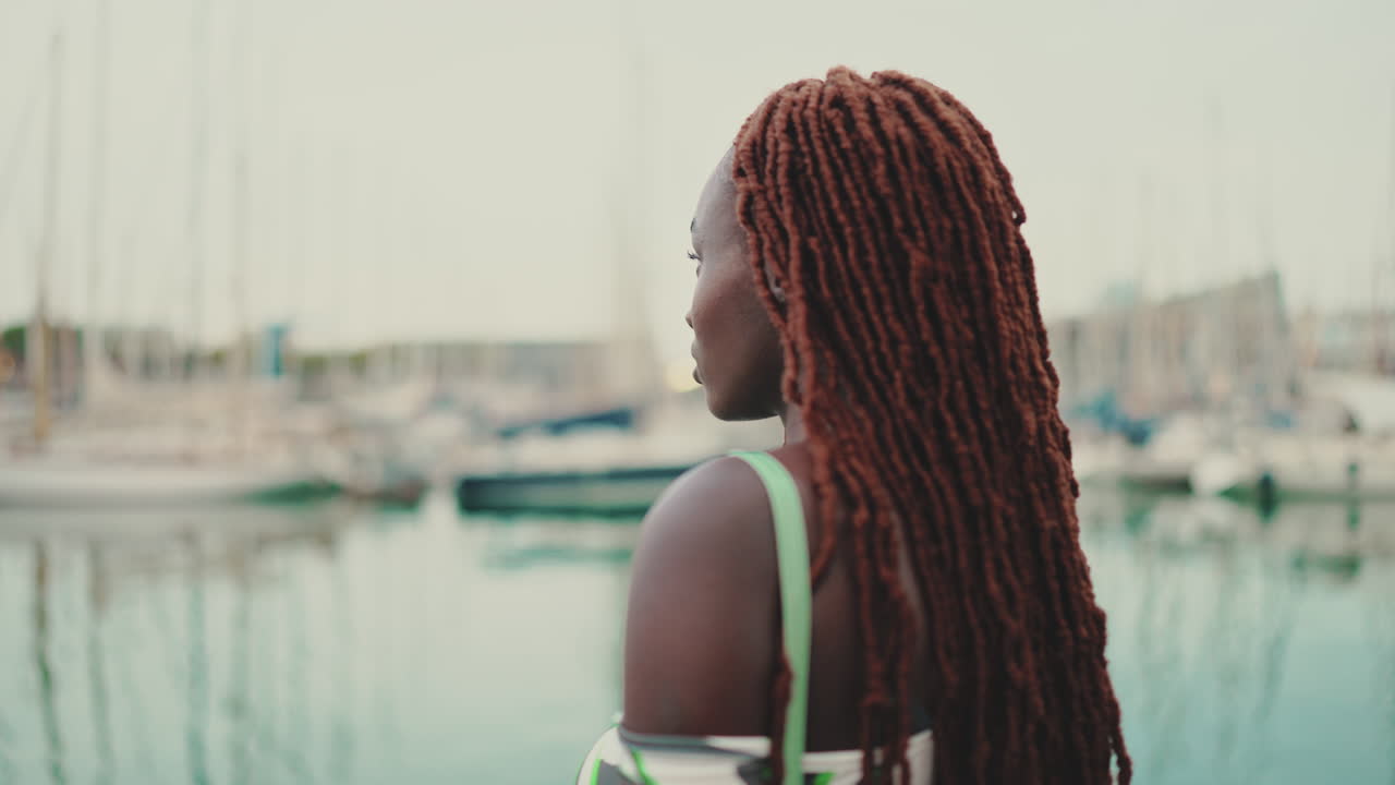 Donna con dreadlocks su un molo