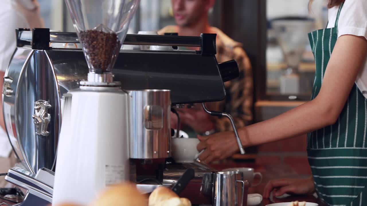 Barista activating espresso machine and holding cup, causing data graphs climbing over cafe counter