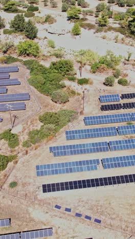 aerial view of a solar panel farm in a rural landscape during daylight