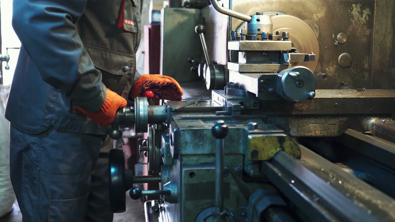 Young mechanic working on a lathe. Metalworking industry.