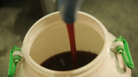 filling a large plastic barrel with liquid