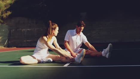 woman and man playing tennis on a sunny day