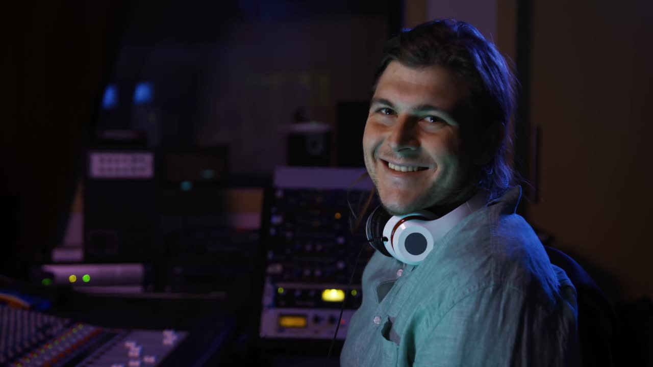 ingeniero de sonido masculino sentado en un escritorio de mezcla